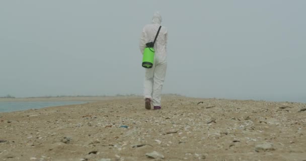 Onderzoeker in beschermende overall en masker lopen in radioactief gebied. — Stockvideo