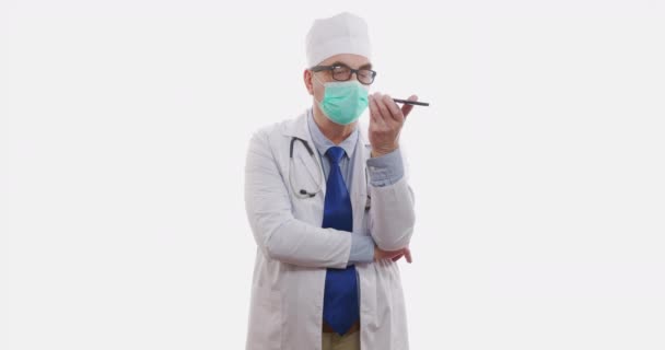 Senior Doctor parla su Smartphone su sfondo bianco.rallentamento, 6k . — Video Stock