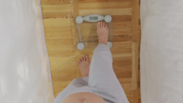 Gravid kvinna stående på skalan, närbild, 6k. — Stockvideo