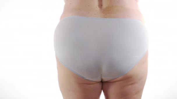 Woman shaking buttocks on a white background. Close-up. 6k. — Stock Video