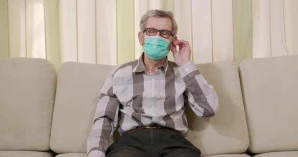Retrato del anciano con máscara médica en la cara. Un hombre se quita la máscara. . — Vídeos de Stock