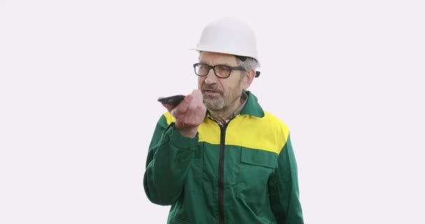 Retrato del viejo hombre de negocios con traje y casco aislado sobre fondo blanco hablando por teléfono . — Vídeos de Stock