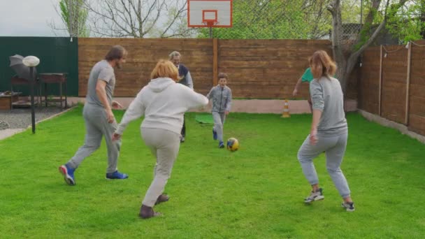 Familie spielt zu Hause auf der Wiese Fußball. Familie, Sport und ein gesunder Lebensstil. — Stockvideo