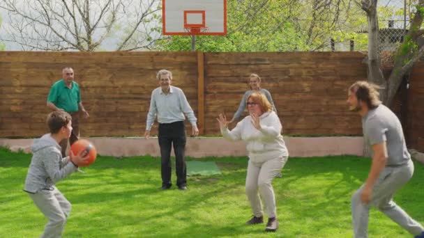 Familjen leker med en basketboll på baksidan. — Stockvideo