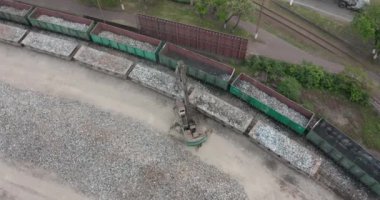 Yüklü yük vagonlarının üzerinden uçup endüstriyel tren istasyonundan ayrılıyoruz..