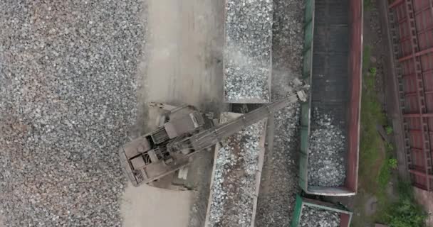 Vue aérienne. Vaste site d'excavation avec un fonctionnement continu des excavatrices chargeant des pierres sur les wagons . — Video