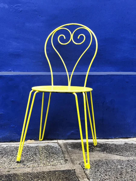 青い背景を持つ黄色の椅子 — ストック写真