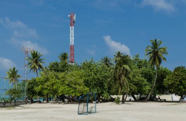 Gulhi Island, Maldivler Kasım, 2017: Futbol sahası palmiye ağaçları ve telekomünikasyon kule, Gulhi Adası, Maldivler arka plan üzerinde.