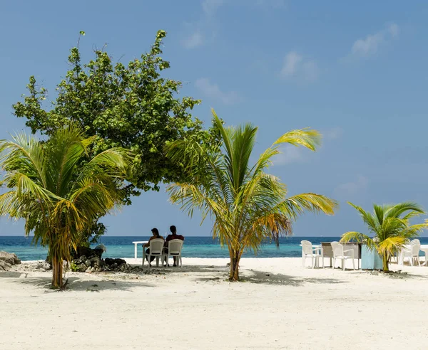 Maldív-szigetek November, 2017: Pihenő pár: tropical beach, Maafushi island, Maldív-szigetek, Indiai-óceán — Stock Fotó