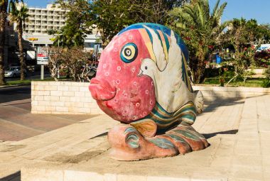 Eilat, İsrail - 7 Kasım 2017: pitoresk heykel, cityscape, Eilat, İsrail çerçevede Kent Müzesi yakınındaki boyalı güvercin ile parlak renklerde balık şeklinde 