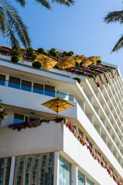 Eilat, İsrail 7 Kasım 2017: Alt görünümü güzel balkon çiçek ve otel Royal Beach, Eilat, İsrail Eilat güvertede bulunan sarı şemsiye ile dekore edilmiştir. Seyahat ve Turizm kavramı.
