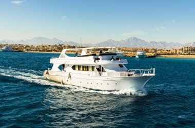 Hurgada, Mısır - 21 Ocak 2017: Hurghada, dağ zirveleri ve mavi gökyüzü binalar karşı Red Sea'deki/daki bembeyaz yat. Hurghada - Mısır'daki ünlü tatil. Seyahat ve Turizm kavramı