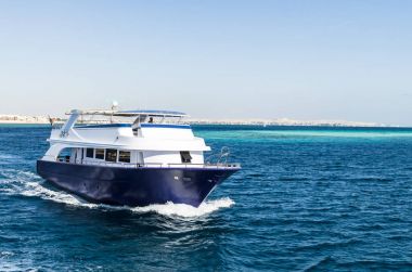 Hurgada, Mısır - 21 Ocak 2017: Hurghada, dağ zirveleri ve mavi gökyüzü binalar karşı Red Sea'deki/daki bembeyaz yat. Hurghada - Mısır'daki ünlü tatil. Seyahat ve Turizm kavramı