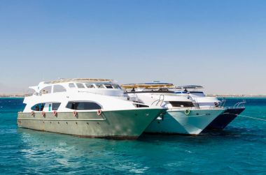 Hurgada, Mısır - 21 Ocak 2017: Kızıldeniz parlak mavi gökyüzü karşı Bay üç Yatlar demirli. Dalış turistler, Mısır bekleyen Yatlar. Seyahat ve Turizm kavramı