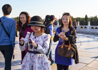 Beijing, Çin - 15 Ekim 2013: akıllı telefonlar karmaşık cennet Tapınağı, Beijing, Çin kullanarak fotoğraf yapma gülümseyen genç kadın