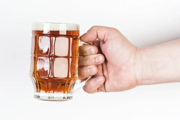 Un vaso de cerveza en una mano aislada sobre fondo blanco . — Foto de Stock