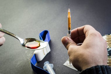 Uyuşturucu veya diğer ilaç ve bir sy kaşıkla tutan erkek el