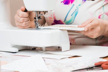 Beyaz dikiş makinesi için çalışan eller. Scrapbooking 