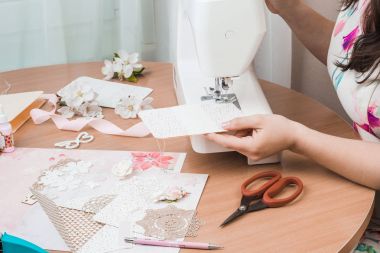 Beyaz dikiş makinesi için çalışan eller. Scrapbooking 