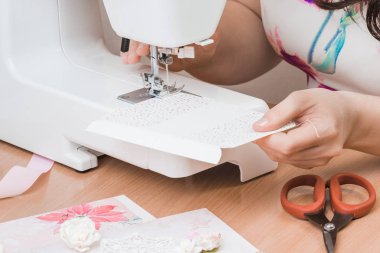 Beyaz dikiş makinesi için çalışan eller. Scrapbooking 