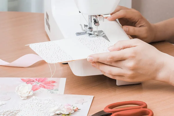 Женские руки работают на белую швейную машинку. Скрапбукинг — стоковое фото