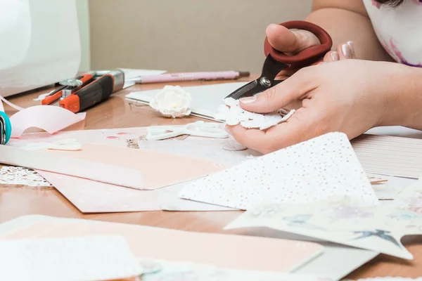 Το χέρι του κοριτσιού κομμένα χαρτί, scrapbooking για γάμο ή άλλες εορταστικές διακοσμήσεις. Εργαλεία για scrapbooking. DIY — Φωτογραφία Αρχείου