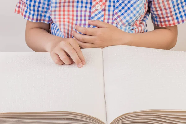 The blind boy is reading a book written on Braille. — Stock Photo, Image