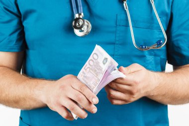 Doktor bir stetoskop ve euro banknot ve kelepçe. 