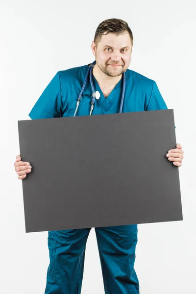 Νεαρός γιατρός, κρατώντας ένα πανό που κενό στα χέρια του αντίγραφο χώρου f — Φωτογραφία Αρχείου