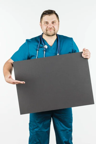 Giovane medico che tiene un banner in bianco nelle mani dello spazio di copia f — Foto Stock