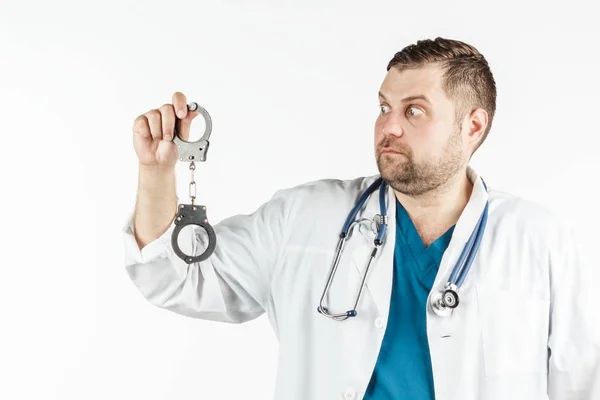 Um médico de jaleco branco com estetoscópio segura a mão — Fotografia de Stock