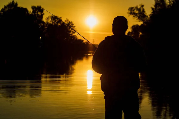 Pêche. tournant au coucher du soleil. Silhouette de pêcheur . — Photo