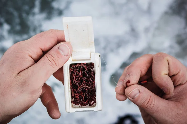 Manos masculinas sosteniendo un cebo para la pesca de invierno — Foto de Stock