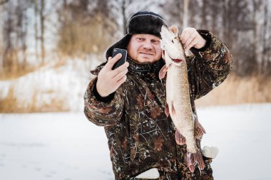 Kış gölde buz balıkçı.