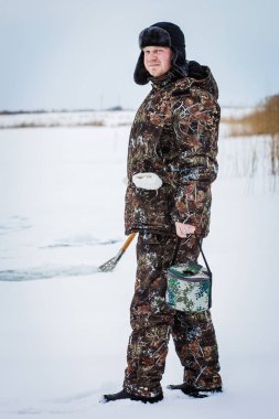 Kış gölde buz balıkçı matkap.