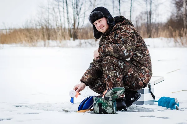 Kış gölde buz balıkçı.