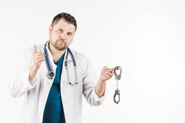 Seorang dokter dalam jas lab putih dengan stetoskop memegang handcu — Stok Foto