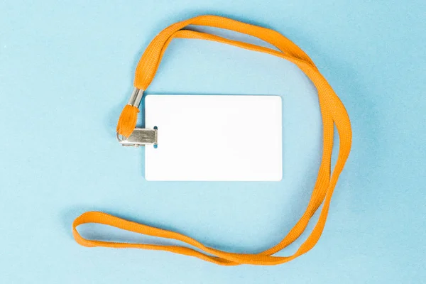 Tarjeta de identificación vacía / icono con cinturón naranja, sobre fondo azul . — Foto de Stock