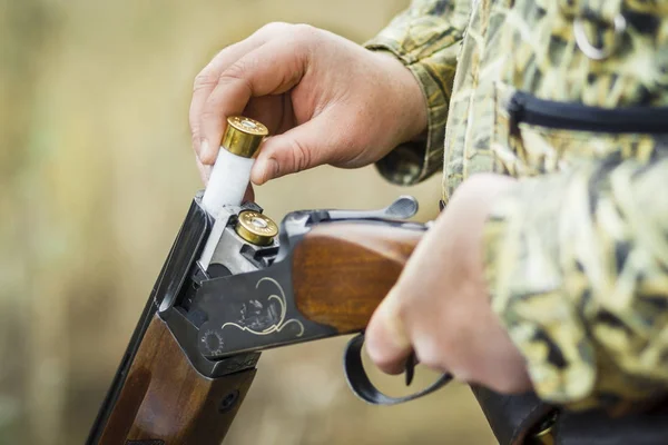 Man charging double-barreled hunting rifle closeup.