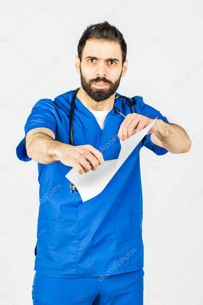 A portrait of a male doctor, tearing and tearing paper. Bad diagnosis, wrong treatment, lost, upset. on a white background