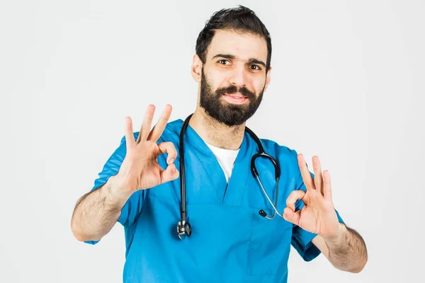 Porträt eines Arztes in blauer Uniform mit erhobenem Daumen. isoliert — Stockfoto