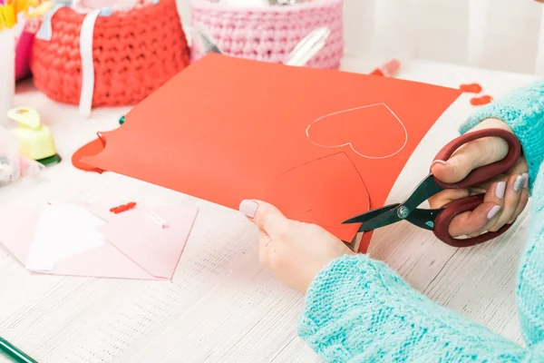 Tema hari Valentine. Tangan perempuan memotong jantung keluar dari pap — Stok Foto