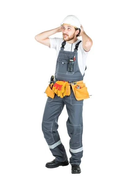 A builder or an employee in a protective helmet is shocked or fr — Stock Photo, Image