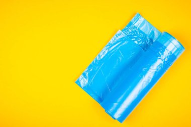 Sarı bir arka plan üzerinde yeni mavi çöp torbaları.