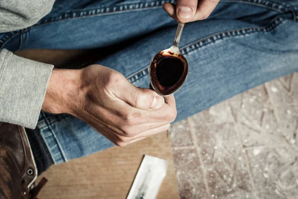De handen van een drugsverslaafde smelten van cocaïne in een lepel. Het hol van een man — Stockfoto