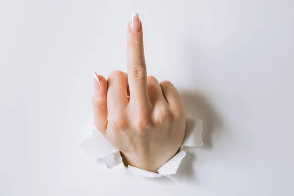 Girl's hand punches the paper and moves the middle finger. — Stock Photo, Image