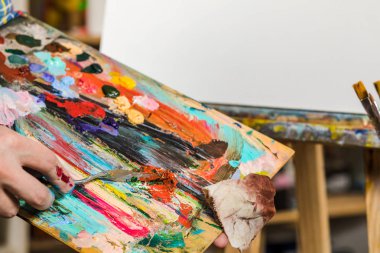 Tuval üzerinde bir fırçayla bir adamın elini. Sanat, yaratıcılık, h