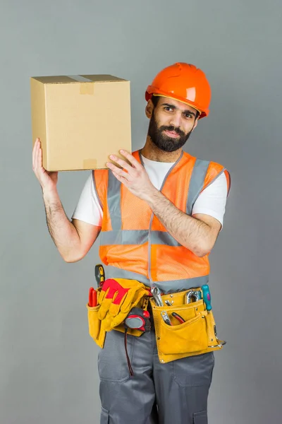 Man Builder Orange Hjälm Med Kartong Hans Händer Grå Bakgrund — Stockfoto