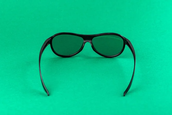 Modern fashion and office glasses isolated on green background.