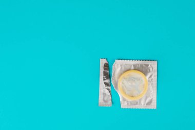 Mavi arka planda prezervatif. Güvenli seks kavramı.